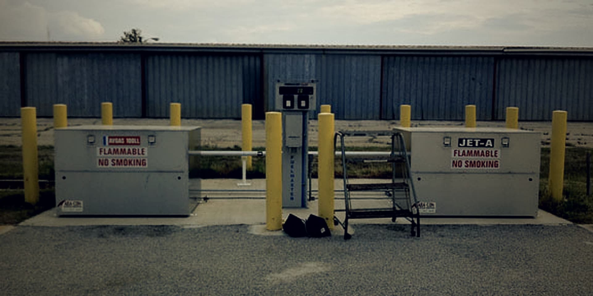 Airport self-serve 100LL and Jet-A FuelMaster cabinets on the KTOC ramp, with hangars behind.